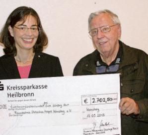 Bettina Schübel übergibt den Scheck an Gerhard Scherr